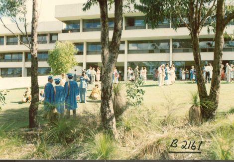 students posing in front of old building