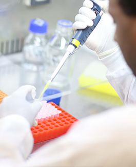 Researcher using a syringe to add a liquid into a tube