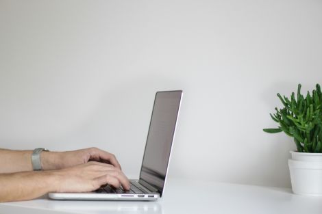 Hands typing on laptop keyboard