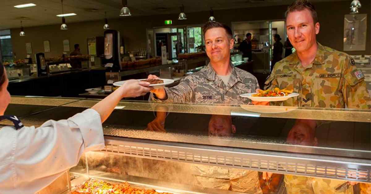 Two members of the armed forces in line for food.