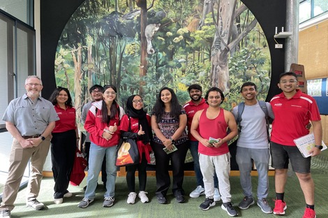 Group of students standing in front of a nature mural at the Eco Centre