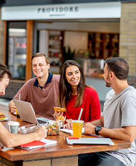 students sitting outside of a cafe