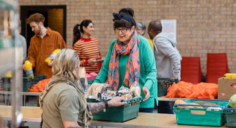 A woman handing out a box of food