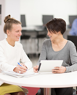 Two students sitting in a library space