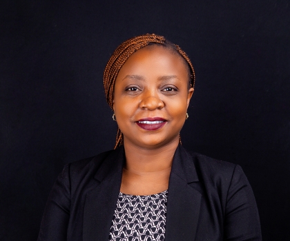 Portrait of Dr Nsofwa Sukwa, a woman with long brown braided hair.